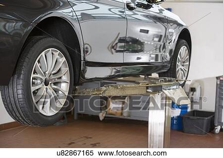 Car on hoist at repair shop View Large Photo Image Stock Photography - Car on hoist at repair shop. Fotosearch