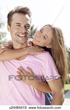 Cheerful young couple enjoying quality time in park View Large Photo Image Stock Photo - Cheerful young couple enjoying quality time in park. Fotosearch