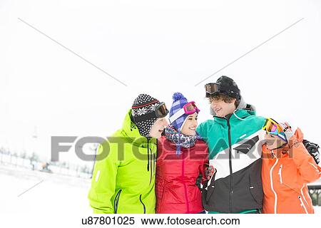 Cheerful young friends standing arm around in snow View Large Photo Image Stock Photography - Cheerful young friends standing arm around in snow. Fotosearch