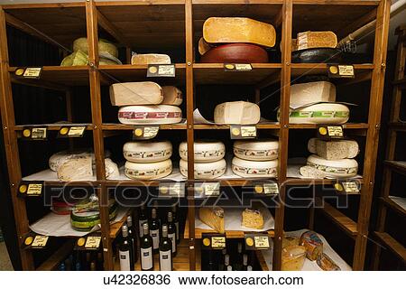 Stock Photograph - Cheese and alcoholic beverages on shelves at store. Fotosearch