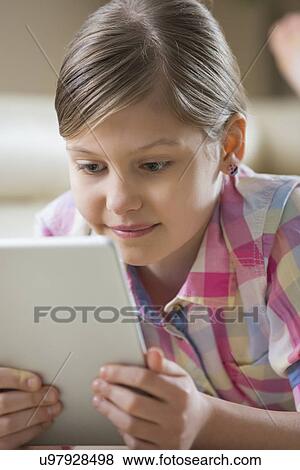Stock Photo - Close-up of girl using digital tablet at home. Fotosearch