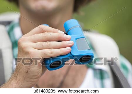 Close-up of male hiker holding binoculars View Large Photo Image Stock Photography - Close-up of male hiker holding binoculars. Fotosearch