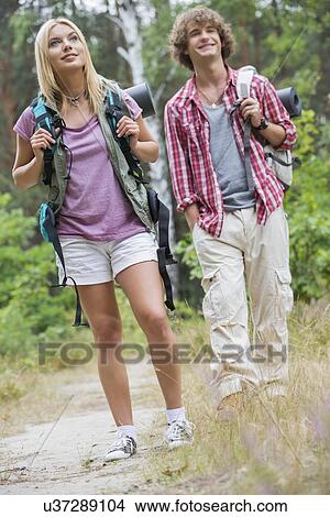 Picture - Couple looking away while hiking in forest. Fotosearch