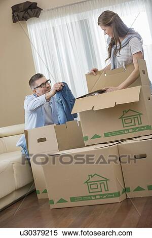 Couple unpacking cardboard boxes in new house View Large Photo Image Stock Photography - Couple unpacking cardboard boxes in new house. Fotosearch
