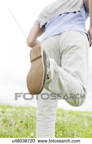 Stock Image - Cropped image of man running in park. Fotosearch