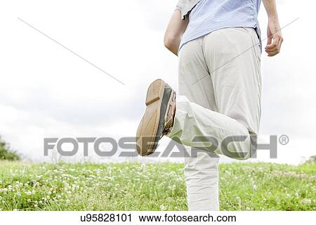 Cropped image of man running in park against sky View Large Photo Image Stock Image - Cropped image of man running in park against sky. Fotosearch