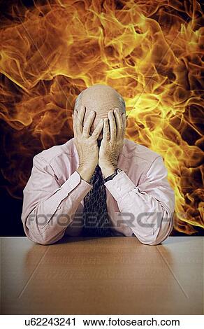 Depressed senior businessman sitting at desk with fire in background View Large Photo Image Stock Image - Depressed senior businessman sitting at desk with fire in background. Fotosearch