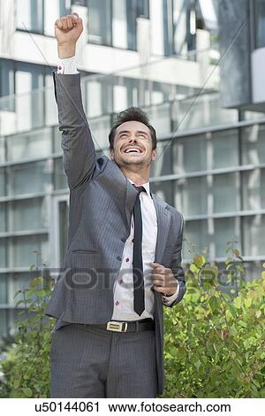 Excited businessman celebrating success outside office building View Large Photo Image Stock Image - Excited businessman celebrating success outside office building. Fotosearch