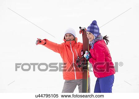Excited female friends with snowboard outdoors View Large Photo Image Stock Photography - Excited female friends with snowboard outdoors. Fotosearch
