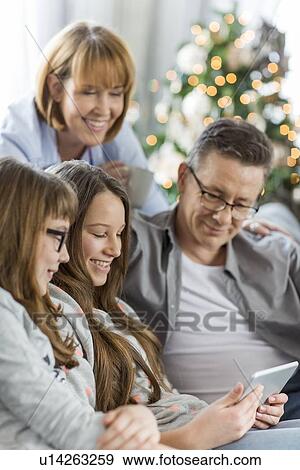 Stock Photo - Family using tablet PC together at home. Fotosearch