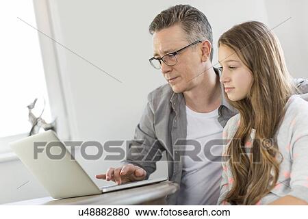 Father and daughter using laptop at home View Large Photo Image Stock Image - Father and daughter using laptop at home. Fotosearch
