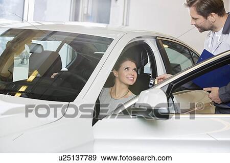 Female customer receiving car key from mechanic in automobile repair shop View Large Photo Image Stock Photo - Female customer receiving car key from mechanic in automobile repair shop. Fotosearch