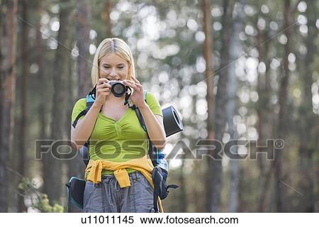 Female hiker photographing through digital camera in forest View Large Photo Image Stock Photography - Female hiker photographing through digital camera in forest. Fotosearch