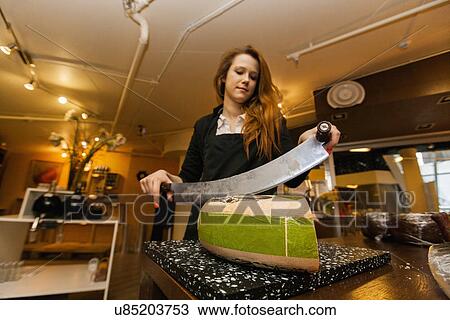 Female salesperson cutting cheese at store View Large Photo Image Stock Image - Female salesperson cutting cheese at store. Fotosearch