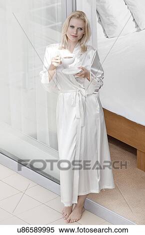Full length of beautiful young woman in robe drinking coffee at balcony doorway View Large Photo Image Stock Photography - Full length of beautiful young woman in robe drinking coffee at balcony doorway. Fotosearch