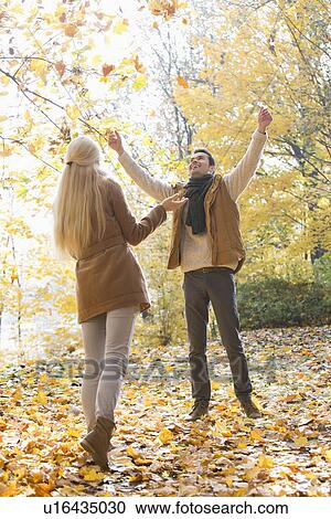 Full length of couple enjoying in autumn View Large Photo Image Stock Image - Full length of couple enjoying in autumn. Fotosearch