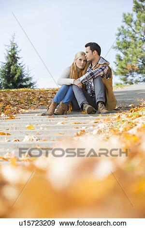 Full length of couple sitting on steps in park View Large Photo Image Stock Photo - Full length of couple sitting on steps in park. Fotosearch