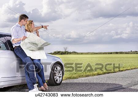 Full length of couple with map discussing direction while leaning on car at countryside View Large Photo Image Stock Image - Full length of couple with map discussing direction while leaning on car at countryside. Fotosearch