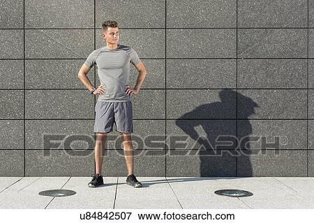 Full length of determined jogger standing against tiled wall outdoors View Large Photo Image Stock Photo - Full length of determined jogger standing against tiled wall outdoors. Fotosearch