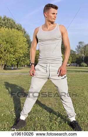 Stock Photograph - Full length of determined jogger standing in park. Fotosearch