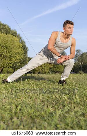 Full length of determined man exercising in park View Large Photo Image Stock Image - Full length of determined man exercising in park. Fotosearch
