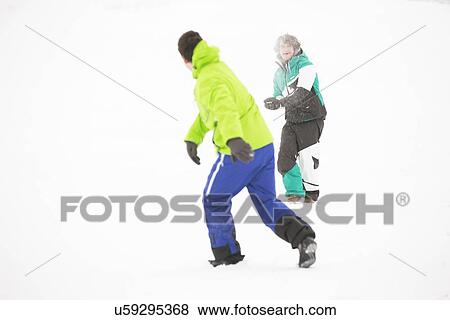 Full length of friends having snowball fight View Large Photo Image Stock Photo - Full length of friends having snowball fight. Fotosearch