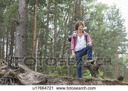 Full length of male backpacker standing in forest View Large Photo Image Stock Image - Full length of male backpacker standing in forest. Fotosearch