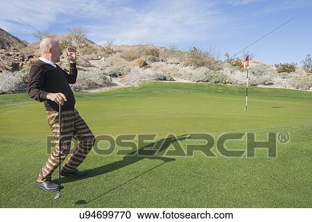 Full length of senior male golfer looking away at golf course View Large Photo Image Stock Image - Full length of senior male golfer looking away at golf course. Fotosearch