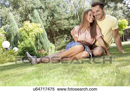 Stock Photography - Full length of smiling young couple spending time together in park. Fotosearch