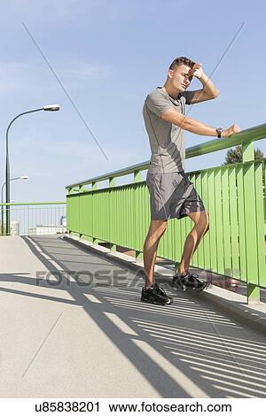 Full length of tired man wiping sweat on bridge after jogging View Large Photo Image Stock Image - Full length of tired man wiping sweat on bridge after jogging. Fotosearch
