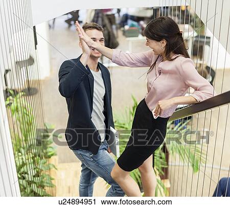 Full length of young business couple doing high-five on staircase View Large Photo Image Stock Image - Full length of young business couple doing high-five on staircase. Fotosearch
