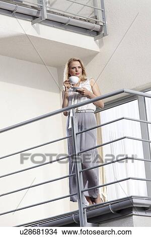 Full length of young businesswoman having coffee at hotel balcony View Large Photo Image Picture - Full length of young businesswoman having coffee at hotel balcony. Fotosearch