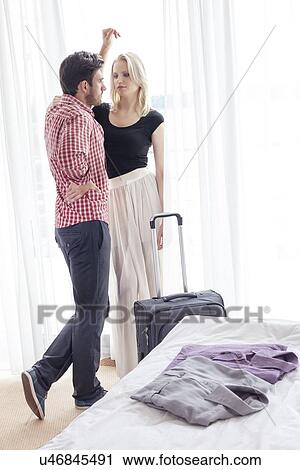 Stock Image - Full length of young couple spending quality time in hotel room. Fotosearch