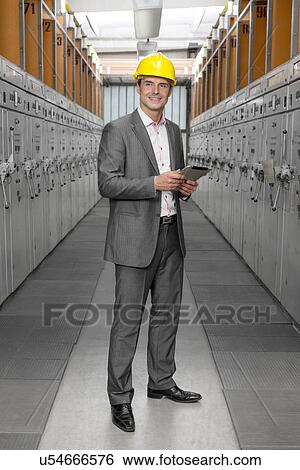 Full length of young male supervisor with digital tablet examining machines in industry View Large Photo Image Stock Photograph - Full length of young male supervisor with digital tablet examining machines in industry. Fotosearch