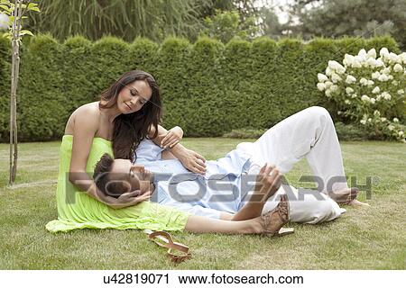 Full length of young man lying on woman's lap in park View Large Photo Image Stock Image - Full length of young man lying on woman's lap in park. Fotosearch