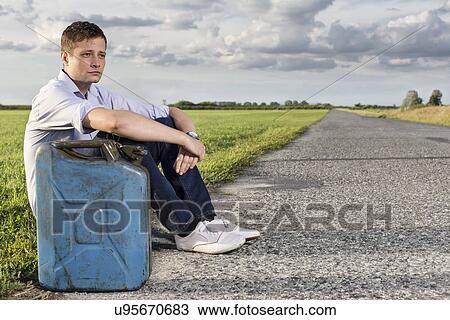 Full length of young man with empty gas can sitting by road View Large Photo Image Stock Image - Full length of young man with empty gas can sitting by road. Fotosearch