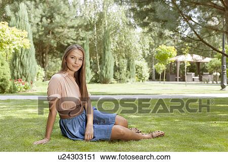 Full length portrait of beautiful young woman relaxing in park View Large Photo Image Stock Image - Full length portrait of beautiful young woman relaxing in park. Fotosearch