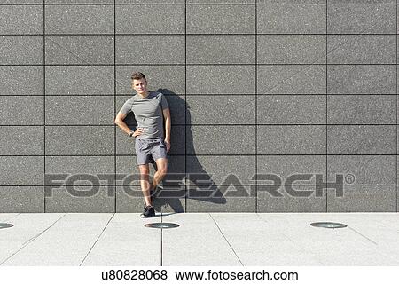 Full length portrait of confident sporty man leaning on tiled wall View Large Photo Image Stock Photo - Full length portrait of confident sporty man leaning on tiled wall. Fotosearch