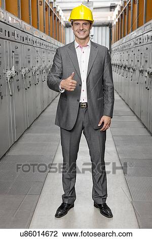 Full length portrait of confident young male supervisor gesturing thumbs up in control room View Large Photo Image Stock Image - Full length portrait of confident young male supervisor gesturing thumbs up in control room. Fotosearch