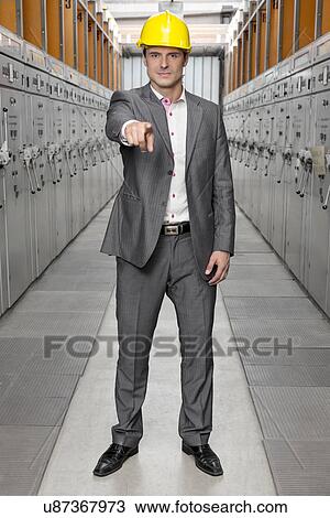 Full length portrait of confident young male supervisor pointing at you in control room View Large Photo Image Stock Image - Full length portrait of confident young male supervisor pointing at you in control room. Fotosearch