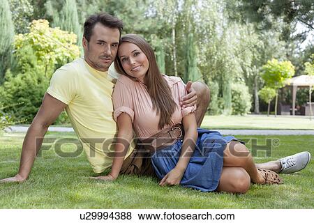 Full length portrait of happy young couple relaxing on grass in park View Large Photo Image Stock Photo - Full length portrait of happy young couple relaxing on grass in park. Fotosearch