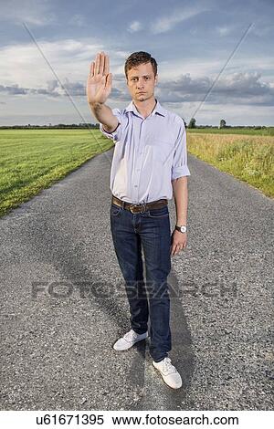Full length portrait of senior young man showing stop gesture on country road View Large Photo Image Stock Photography - Full length portrait of senior young man showing stop gesture on country road. Fotosearch