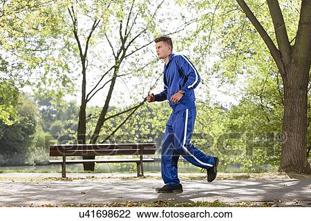 Full length side view of man jogging on path in park View Large Photo Image Stock Image - Full length side view of man jogging on path in park. Fotosearch