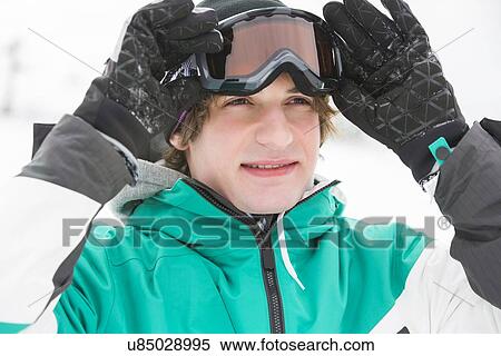 Handsome young man wearing ski goggles outdoors View Large Photo Image Stock Photography - Handsome young man wearing ski goggles outdoors. Fotosearch