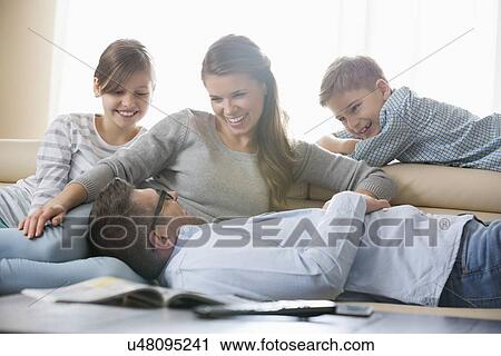 Happy family in living room View Large Photo Image Stock Image - Happy family in living room. Fotosearch