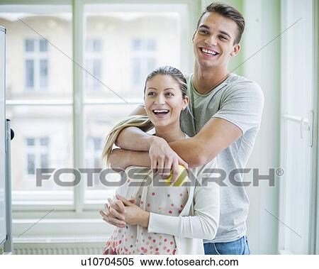 Happy loving couple looking away in house View Large Photo Image Stock Photography - Happy loving couple looking away in house. Fotosearch