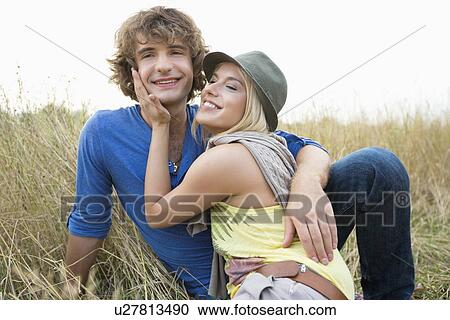Happy loving couple relaxing in field View Large Photo Image Stock Image - Happy loving couple relaxing in field. Fotosearch