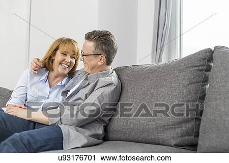 Happy loving couple sitting on sofa at home View Large Photo Image Stock Image - Happy loving couple sitting on sofa at home. Fotosearch