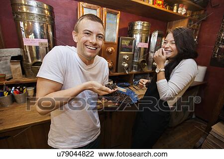 Stock Image - Happy male customer and salesperson at coffee store. Fotosearch
