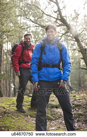 Stock Image - Happy male hikers looking away in forest. Fotosearch